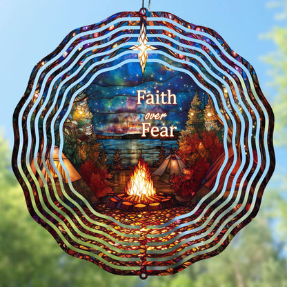 Decorative wind spinner with 'Faith over Fear' text, campfire, and tents against a night sky.